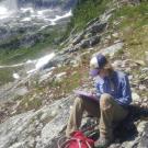 Emily writing notes in the mountains